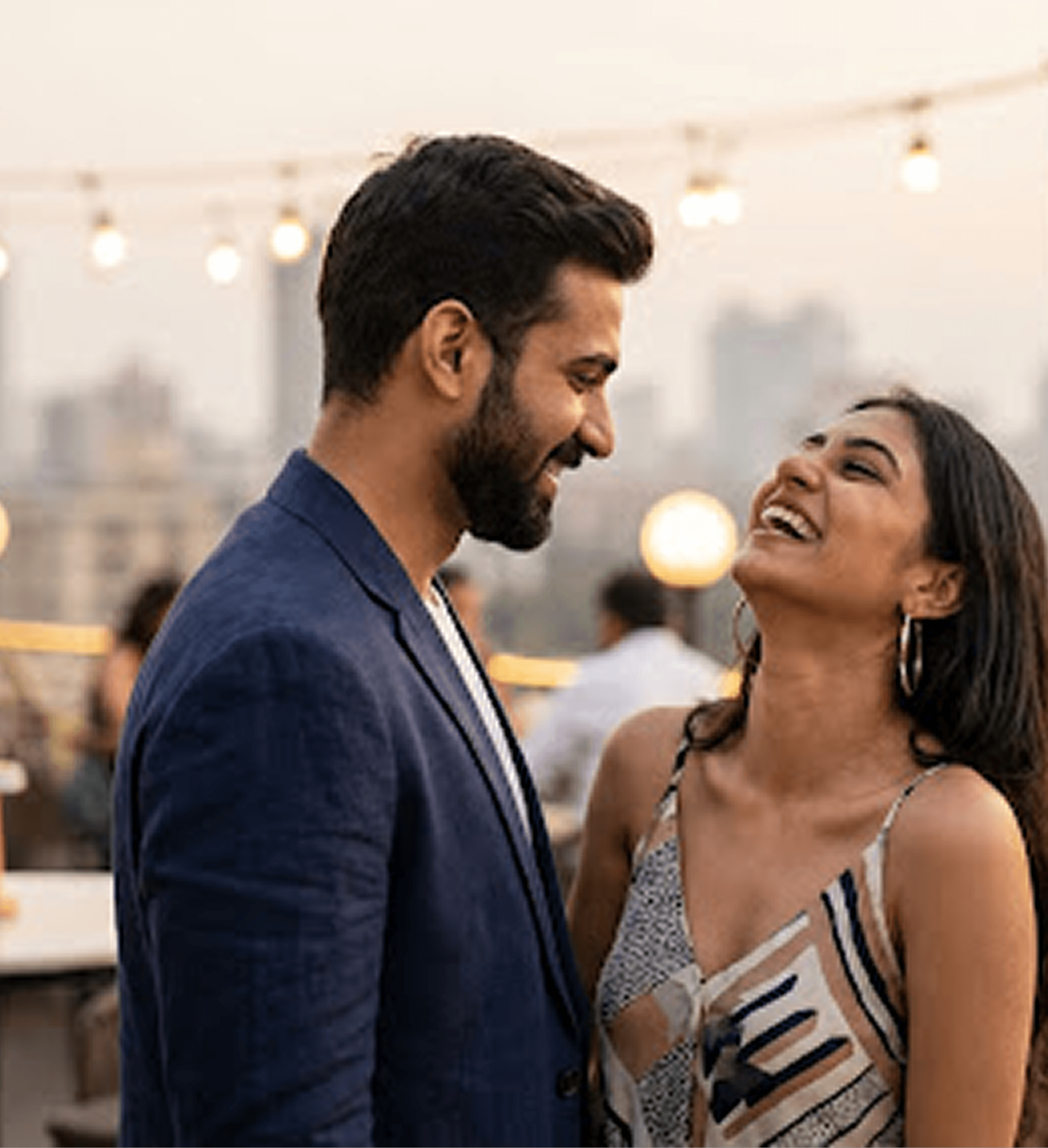 A couple laughing together at a rooftop café in the evening
